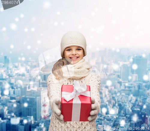 Image of dreaming girl in winter clothes with gift box