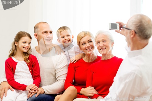 Image of smiling family with camera at home