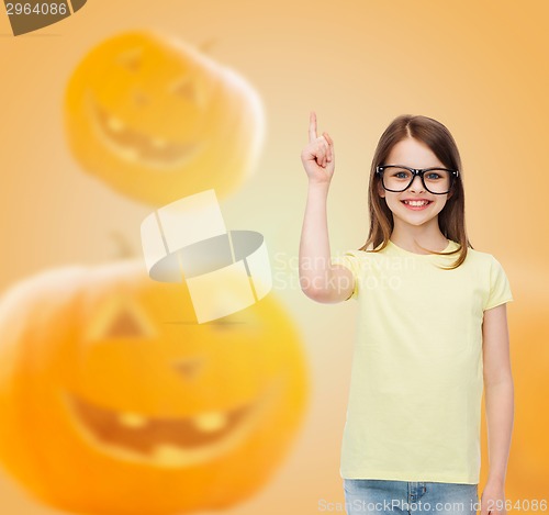 Image of smiling girl in glasses over pumpkins background