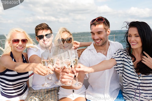 Image of smiling friends with glasses of champagne on yacht