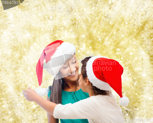 Image of happy mother and girl in santa hats