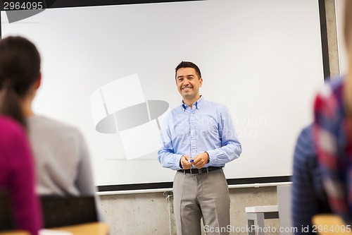 Image of group of students and smiling teacher in classroom