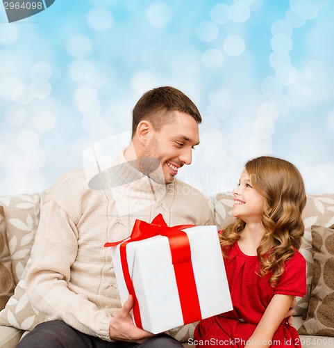 Image of smiling father and daughter with gift box
