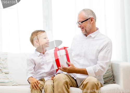 Image of smiling grandfather and grandson at home