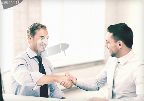 Image of businessmen shaking hands in office