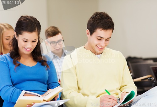 Image of group of smiling students with notebooks