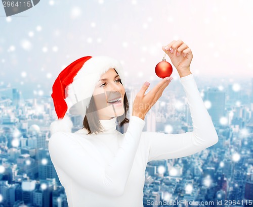 Image of woman in santa helper hat with christmas ball