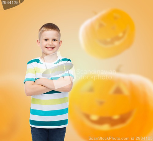 Image of smiling boy over pumpkins background