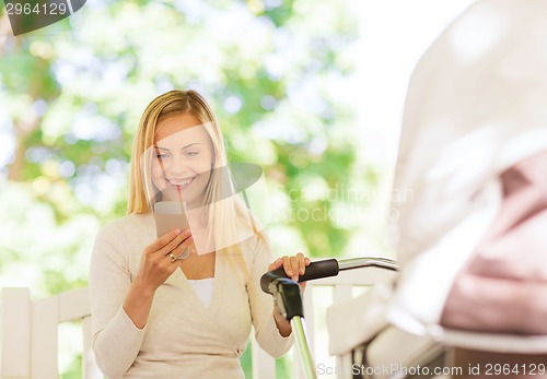 Image of happy mother with smartphone and stroller in park