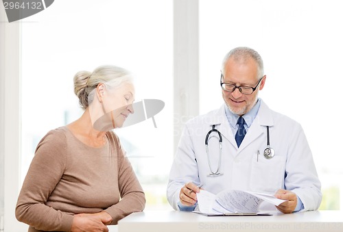 Image of smiling senior woman and doctor meeting