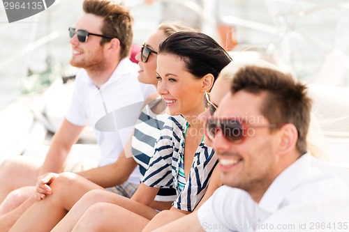 Image of smiling friends sitting on yacht deck