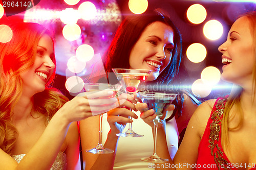 Image of three smiling women with cocktails and disco ball