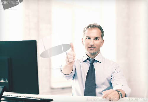 Image of smiling businessman showing thumbs up