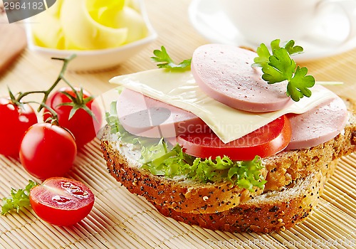 Image of breakfast sandwich with sliced sausage and tomato