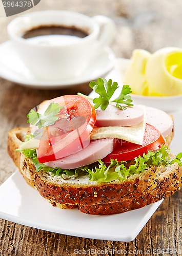 Image of breakfast sandwich with sliced sausage and tomato
