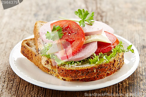 Image of breakfast sandwich with sliced sausage and tomato