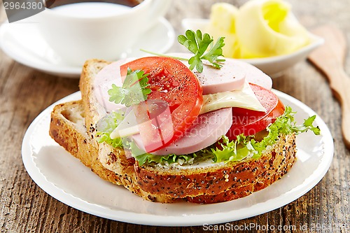 Image of breakfast sandwich with sliced sausage and tomato