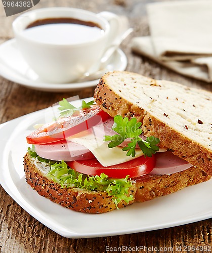 Image of breakfast sandwich with sliced sausage and tomato