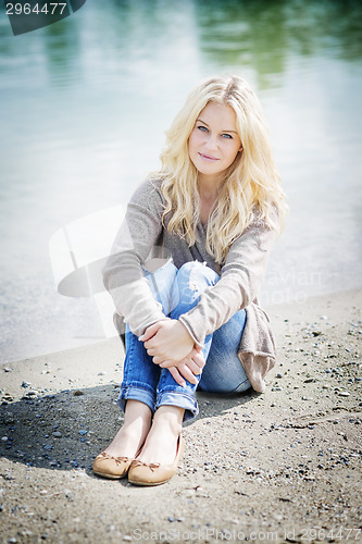 Image of Blond woman sitting at lake