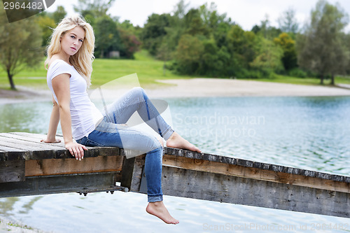 Image of Blond woman sitting on a jetty