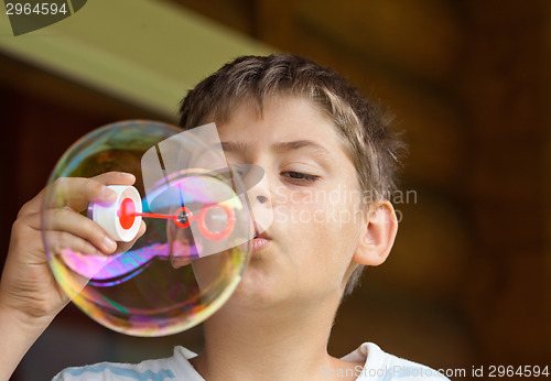 Image of Boy blowing soap bubble