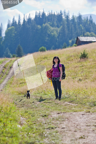 Image of Woman hiking in mountains with dog