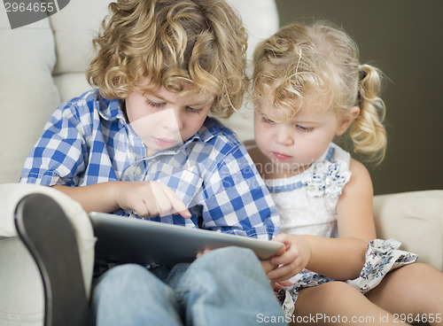 Image of Young Brother and Sister Using Their Computer Tablet Together