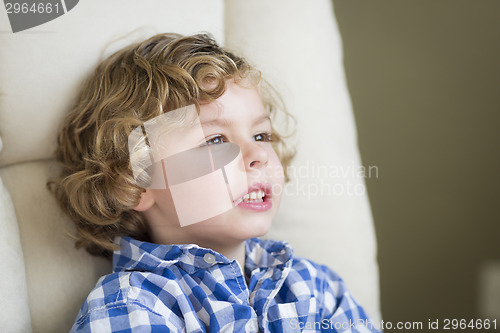 Image of Cute Blonde Boy Daydreaming and Sitting in Chair