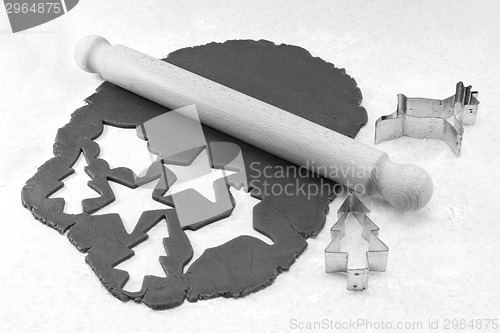 Image of Rolling pin and festive cookie cutters with gingerbread dough