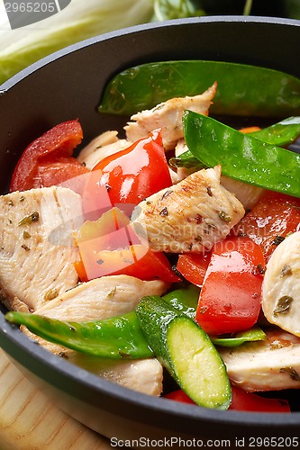 Image of chicken breast meat and vegetables on frying pan