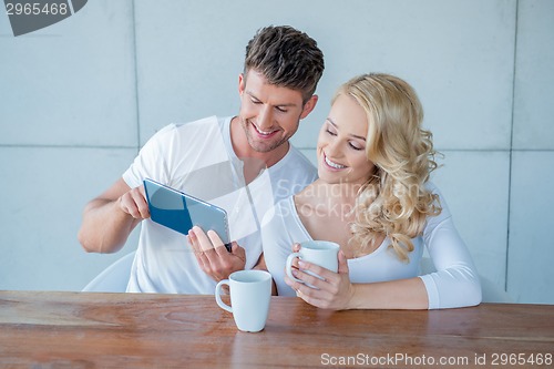 Image of Happy couple surfing the web on a tablet