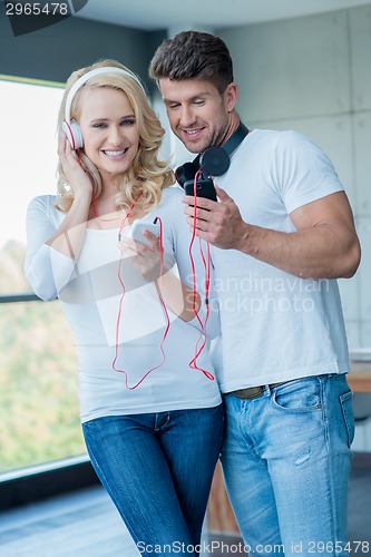 Image of Attractive couple listening to music on headphones