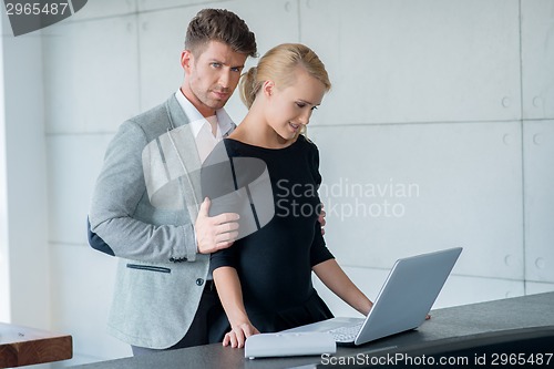 Image of Sweet Young Lovers Using Laptop on Table