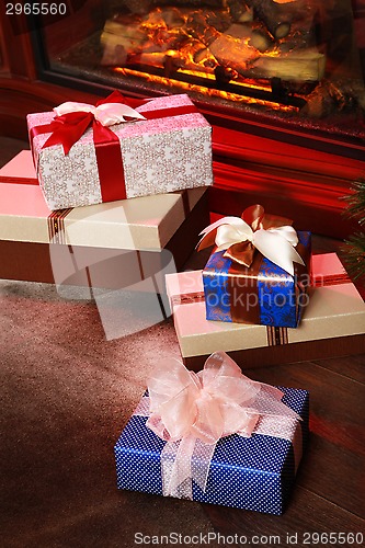 Image of Christmas gifts near fireplace
