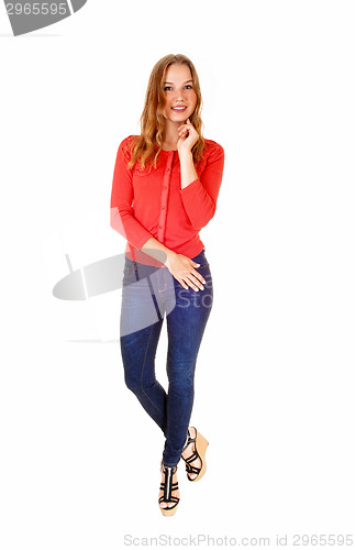 Image of Blond girl in jeans standing.