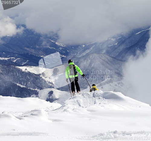 Image of Freeriders on off-piste slope and mountains in haze