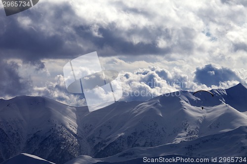 Image of Evening sunlight mountain and silhouette of parachutist