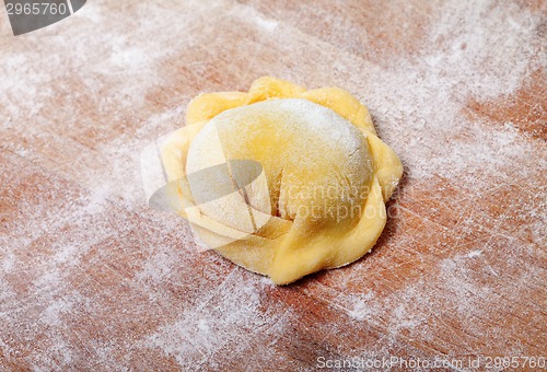 Image of Raw ravioli on wooden cutting board