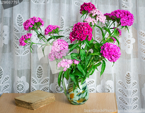 Image of A bouquet of flowers carnations on the table in a glass vase.
