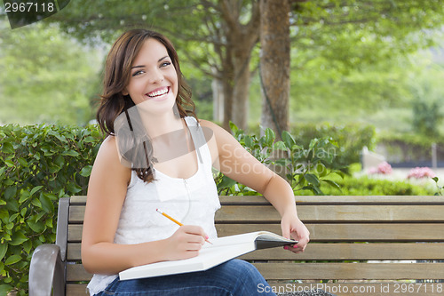 Image of Young Adult Female Student on Bench Outdoors