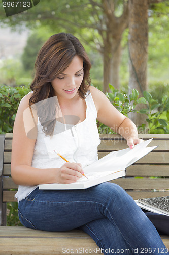 Image of Young Adult Female Student on Bench Outdoors
