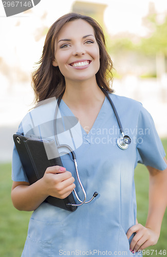 Image of Young Adult Woman Doctor or Nurse Holding Touch Pad Outside