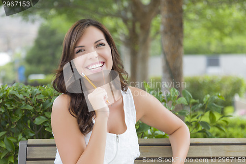 Image of Young Adult Female Student on Bench Outdoors
