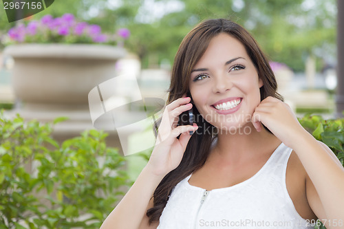Image of Young Adult Female Talking on Cell Phone Outdoors on Bench