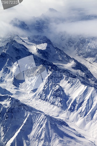 Image of Top view on snow mountains and glacier in fog
