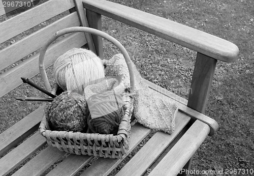 Image of Basket of knitting and yarns on a bench