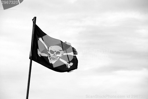 Image of Torn Jolly Roger flies from flagpole