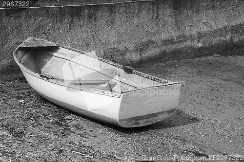 Image of Weather-beaten dinghy on a concrete slipway