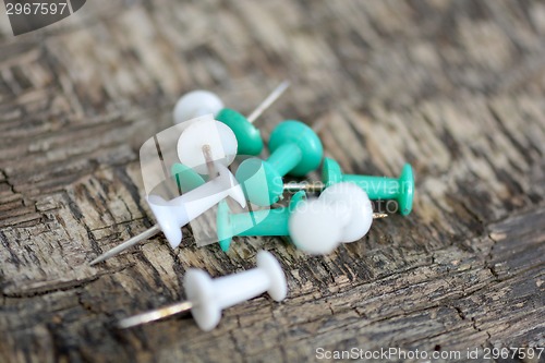 Image of old green and white push pins on old wooden background