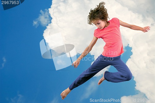 Image of cute young dancer girl jumping against bue sky